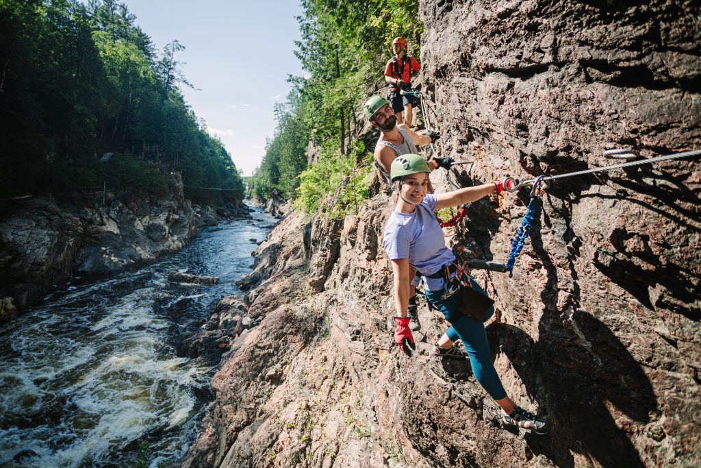 jeune fille souriante utilisant un fil de fer pour escalader le bord de la falaise de la rivière coulonge